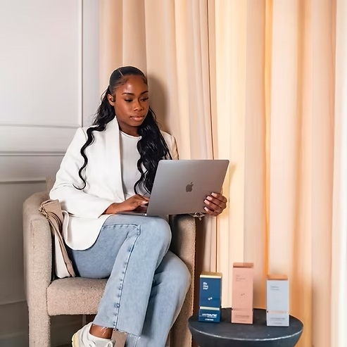 Tashana Cuffy, founder of Faded Skin®, working at her laptop